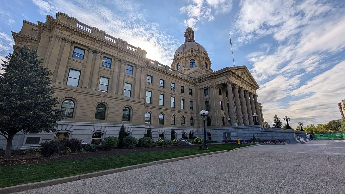 Clădirea Legislativă a provinciei Alberta din Edmonton, cu cupolă și fațadă de piatră, sub un cer parțial noros.
