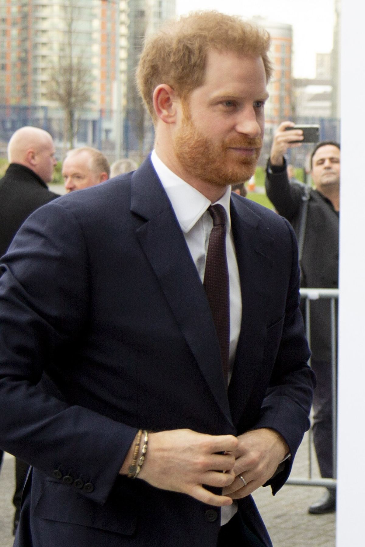 Prințul Harry, în costum bleumarin, cămașă albă și cravată, pe un fundal urban; fotografie de arhivă din 2020.