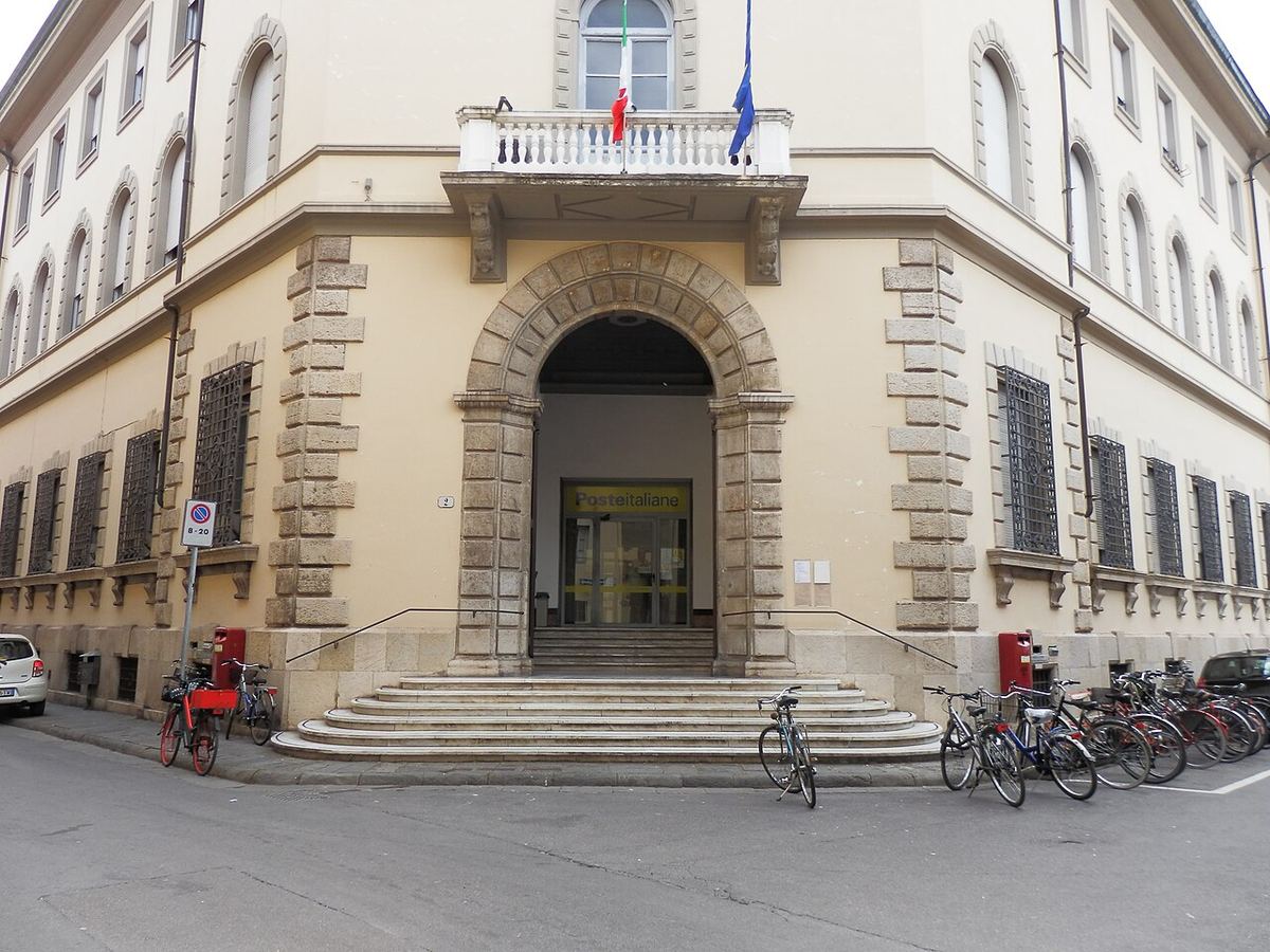 Intrarea clădirii Poștei din centrul istoric al orașului Lucca, Italia, la intersecția dintre două străzi.
