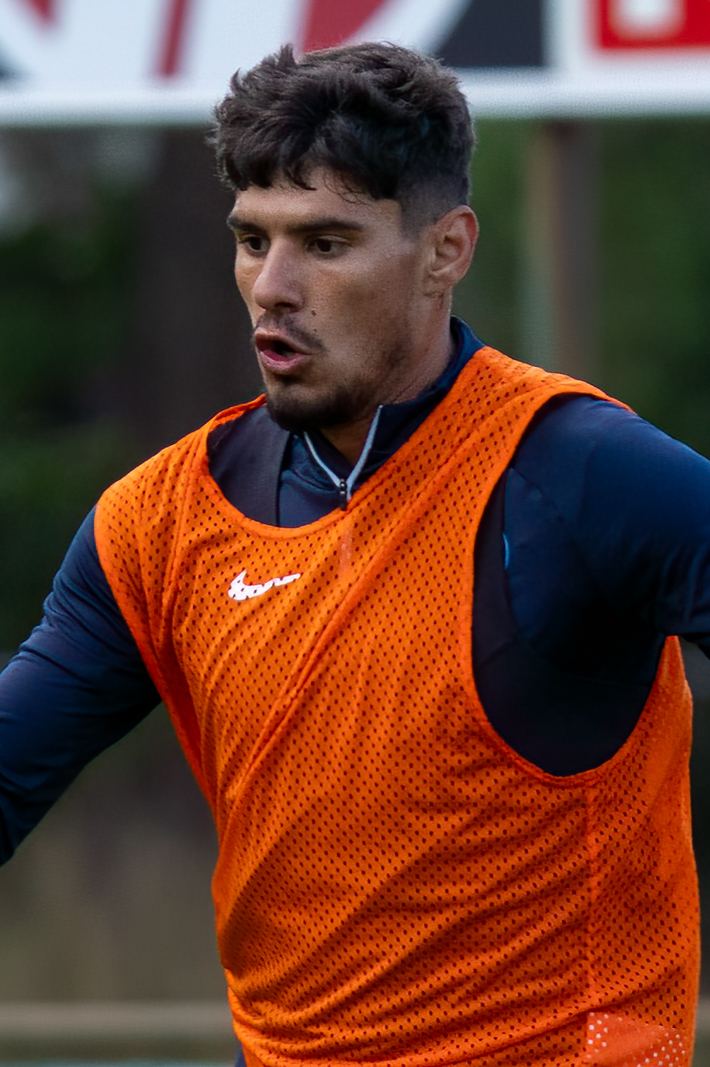 Fotbalistul Florinel Coman cu tricou portocaliu de antrenament, pe teren; fotografie de arhivă din 2023.