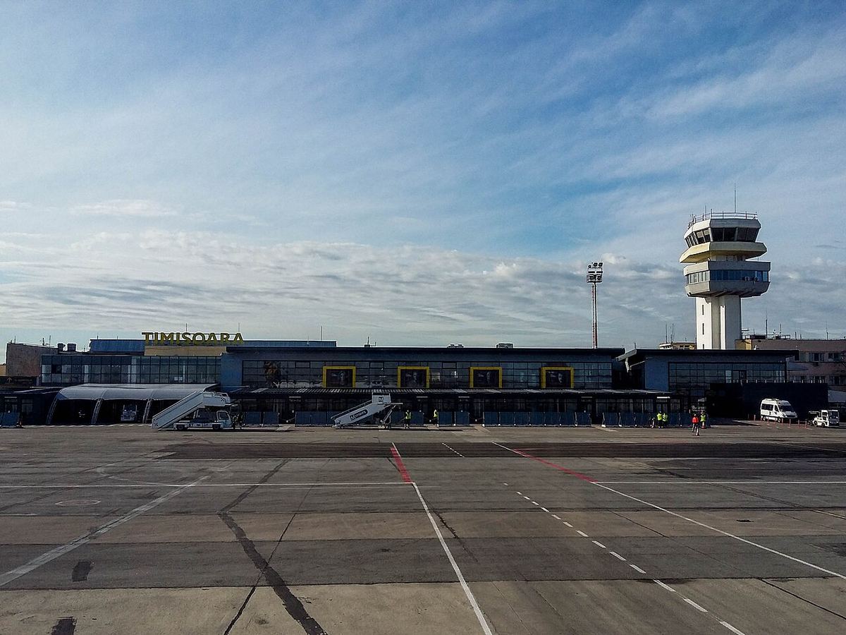 Terminalul Aeroportului Traian Vuia din Timișoara, cu turnul de control și platforma pentru aeronave, pe timp de zi.