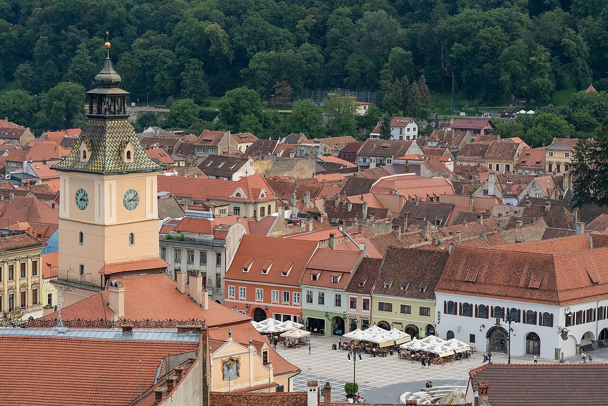 Vedere aeriană a Casei Sfatului și a Pieței Sfatului din Brașov, cu terase de cafenele și clădiri istorice