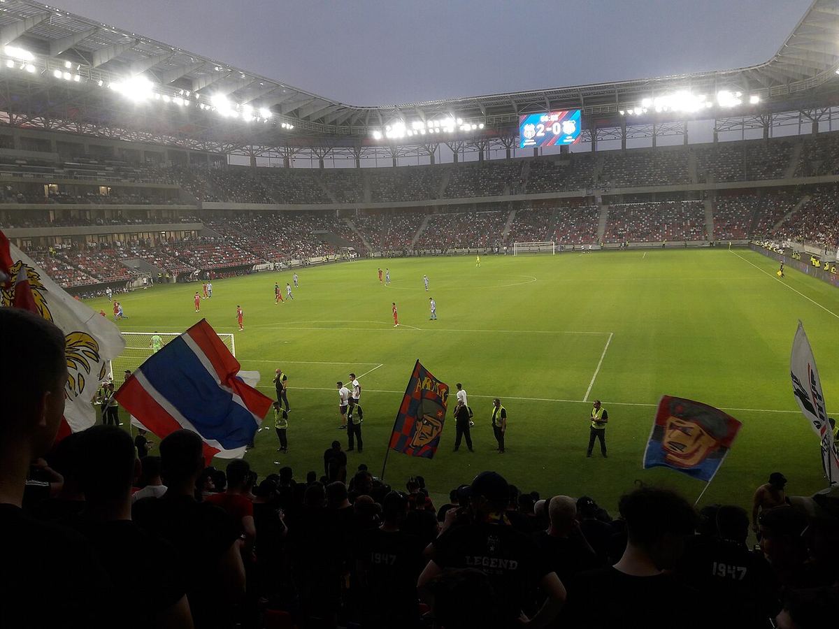 Tribuna stadionului Steaua din București, cu steaguri ale suporterilor, la un meci