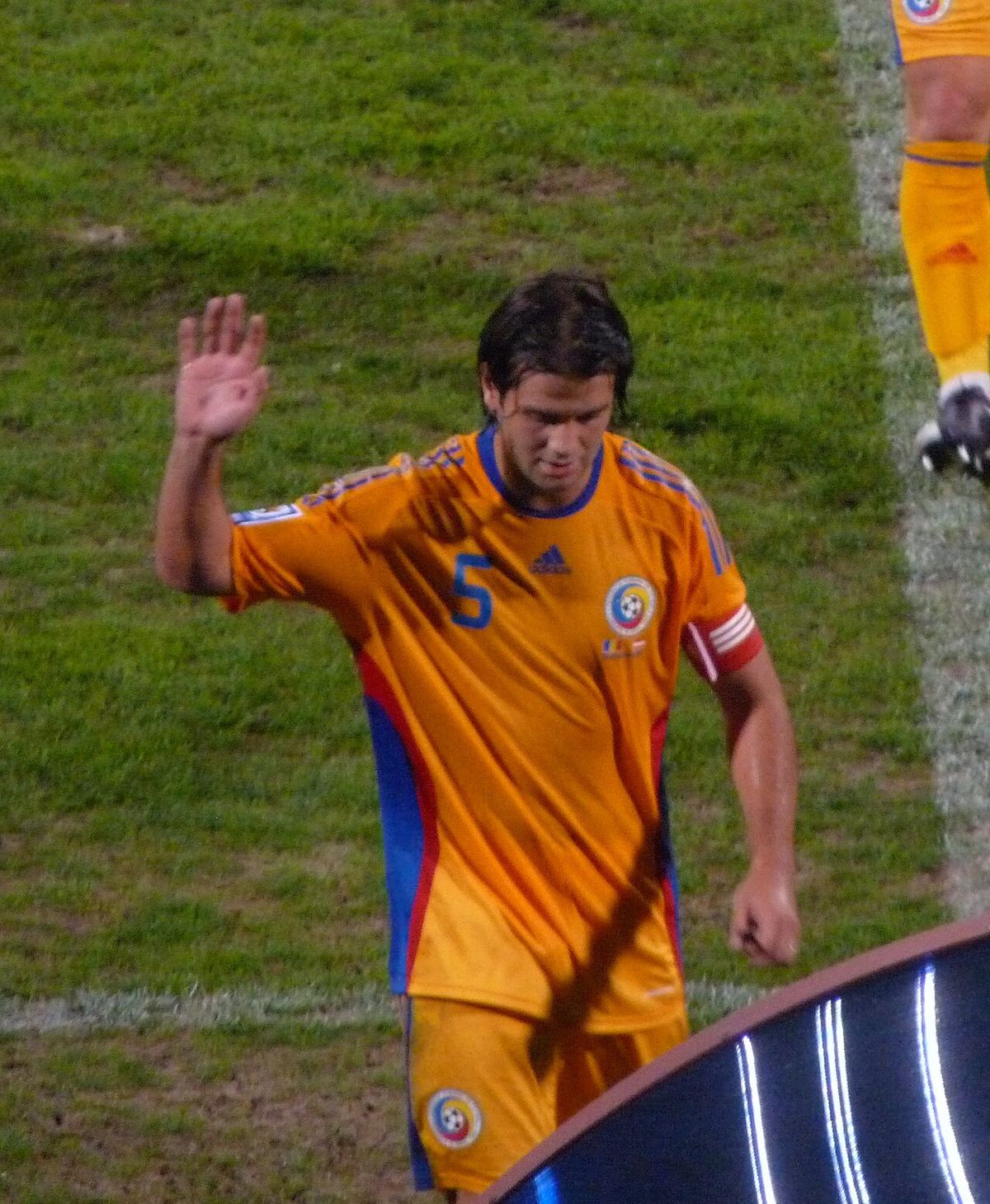 Cristian Chivu, în tricoul echipei naționale a României, cu numărul 5, salutând pe teren. Fotografie de arhivă.