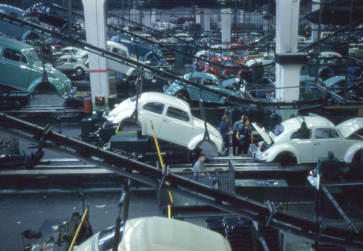 Linie de asamblare Volkswagen la uzina din Wolfsburg, cu caroserii de Beetle suspendate pe transportorul aerian (fotografie de arhivă).