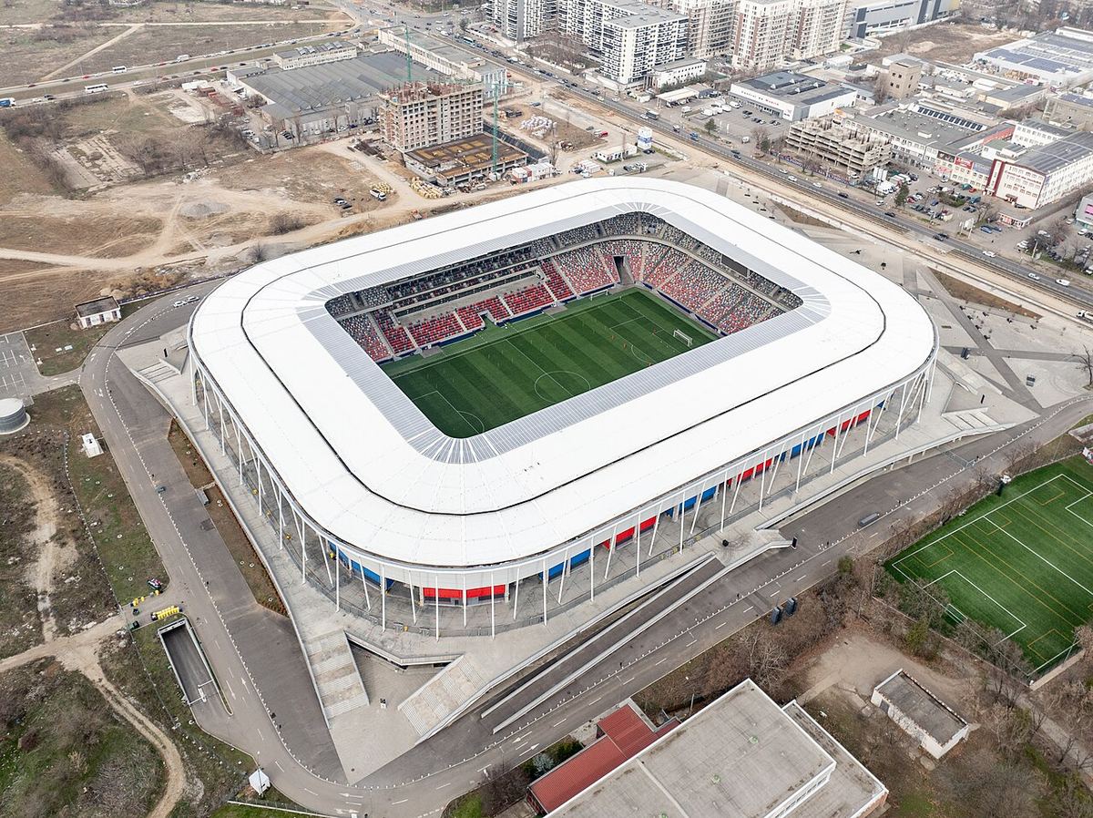 Vedere aeriană a Stadionului Steaua din Ghencea, București, cu gazon verde și tribune sub acoperiș alb.
