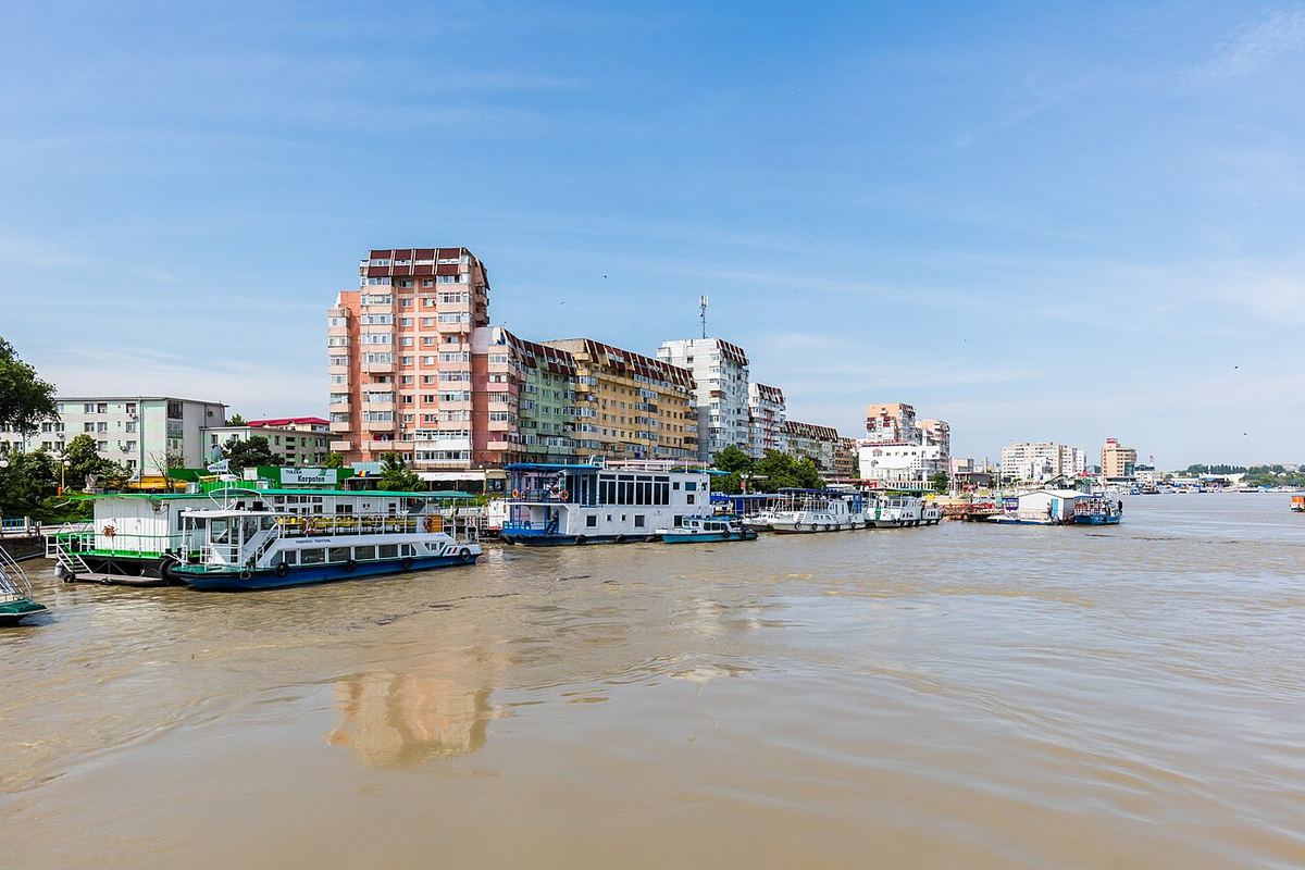 Portul Tulcea din România, văzut de pe malul Dunării, cu ambarcațiuni și infrastructură portuară.