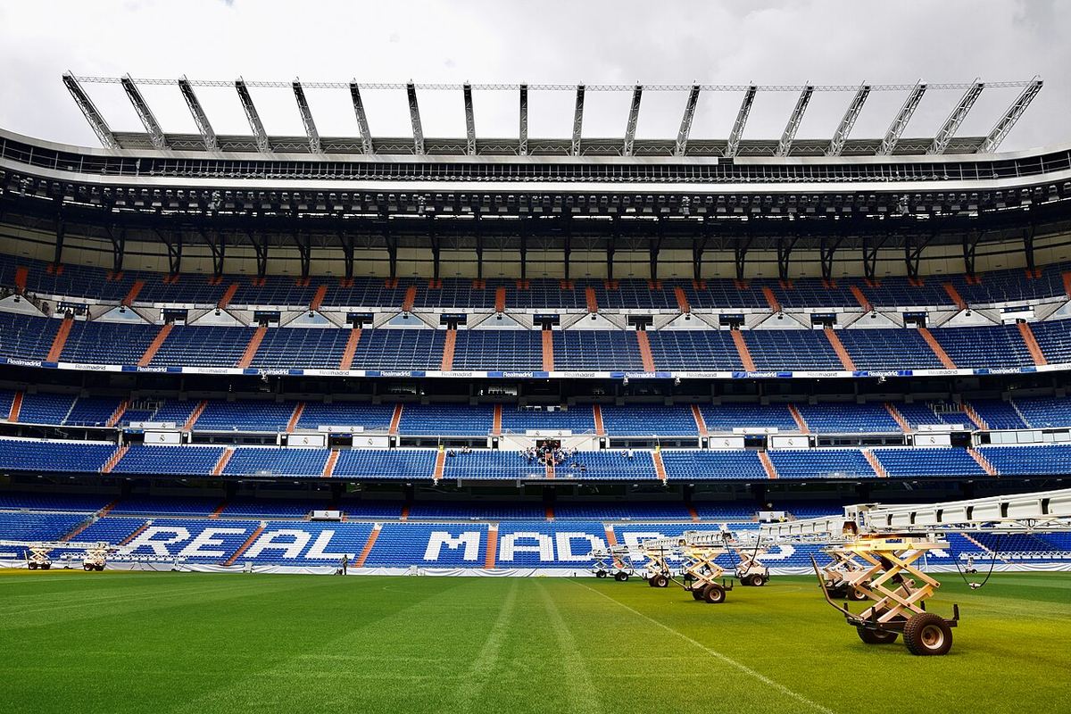 Interiorul stadionului Santiago Bernabéu din Madrid, cu tribunele goale și gazonul pregătit înainte de meci.