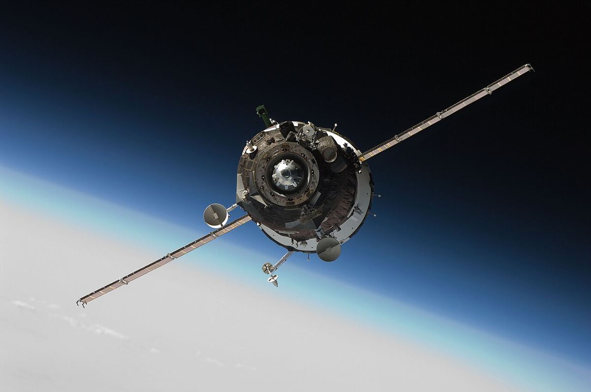 Navă spațială Soyuz pe orbită, cu panouri solare, deasupra limbului Pământului (imagine ilustrativă).