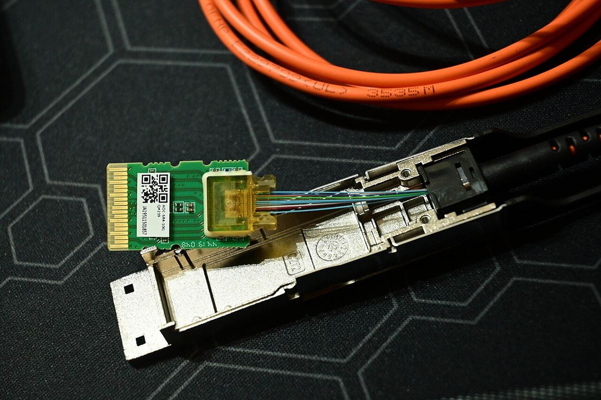 Transceiver QSFP de 40 Gbps demontat, cu componente electronice și conectori de fibră optică vizibili.