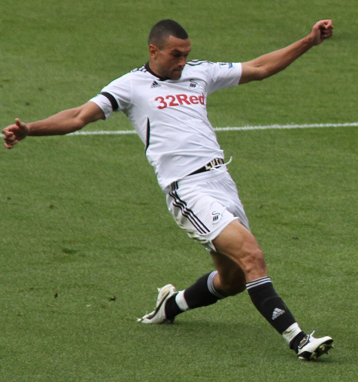Fotografie cu Steven Caulker, fost fundaș de fotbal, pe care apare alături de un alt jucător.