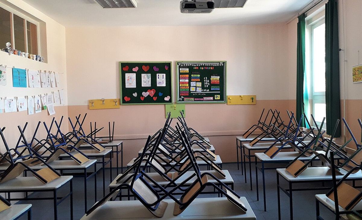 Sală de clasă goală, cu bănci și scaune aliniate, ilustrând școala și mediul educațional.
