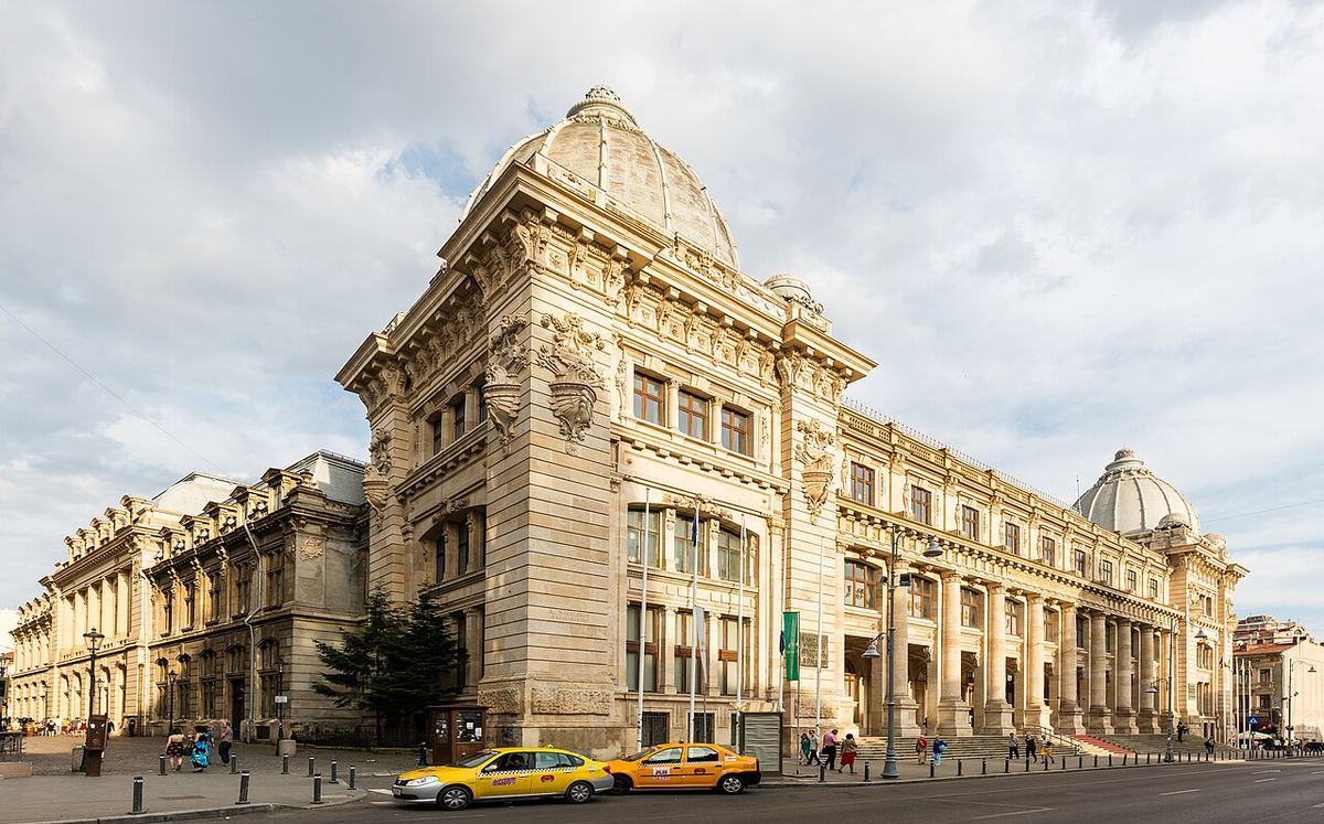 Exteriorul Muzeului Național de Istorie a României din București, cu cupola și fațada sa neoclasică, și taxiuri galbene în prim-plan.