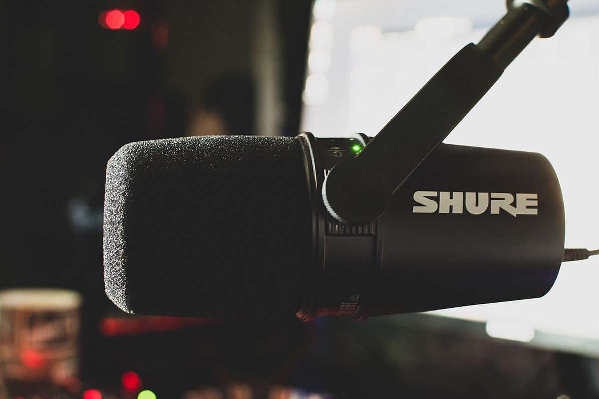Microfon Shure MV7 pe fundal neutru, folosit pentru podcasturi și transmisiuni web.