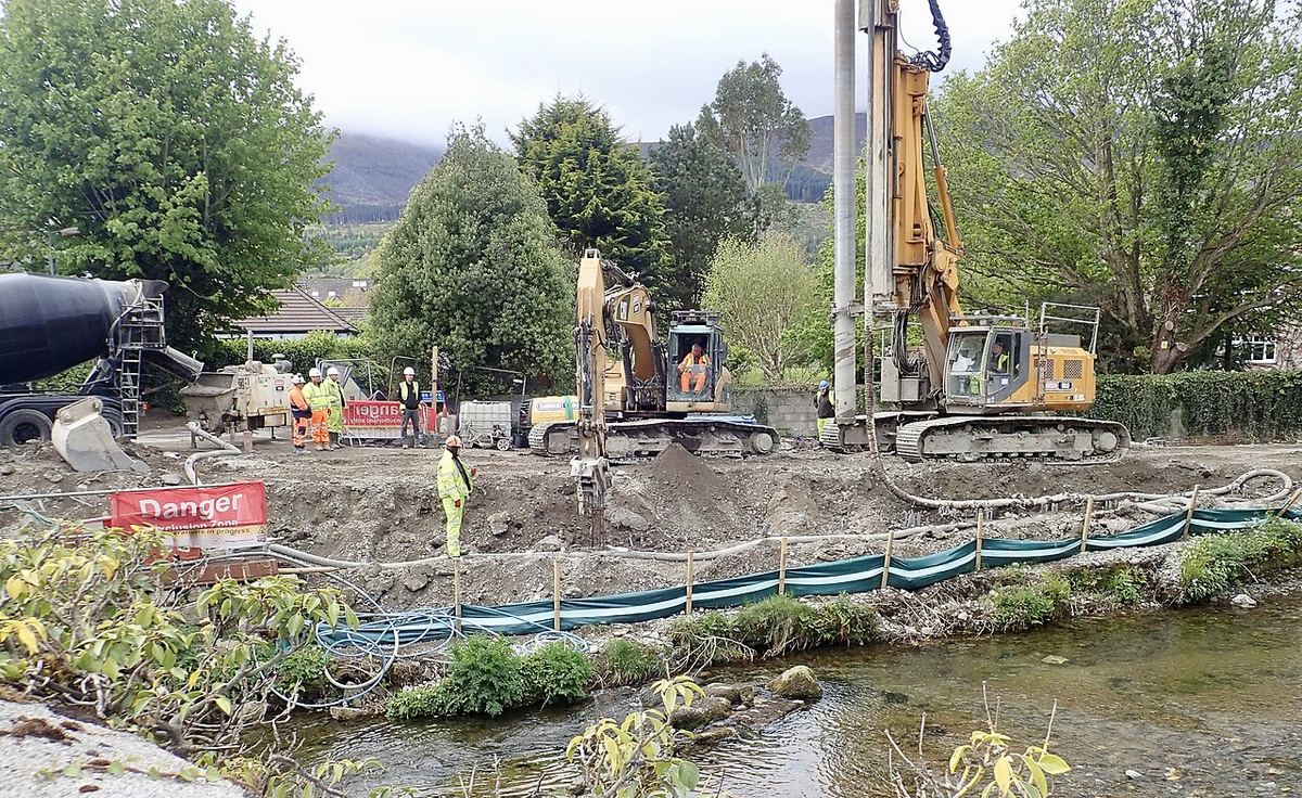 Echipă de foraj cu utilaj de piloți în acțiune pe un șantier de construcții, ilustrativ.