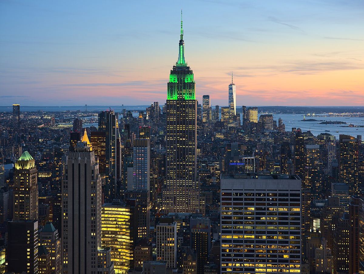 Empire State Building iluminat în verde, la apus, în skyline-ul orașului New York, văzut de sus.