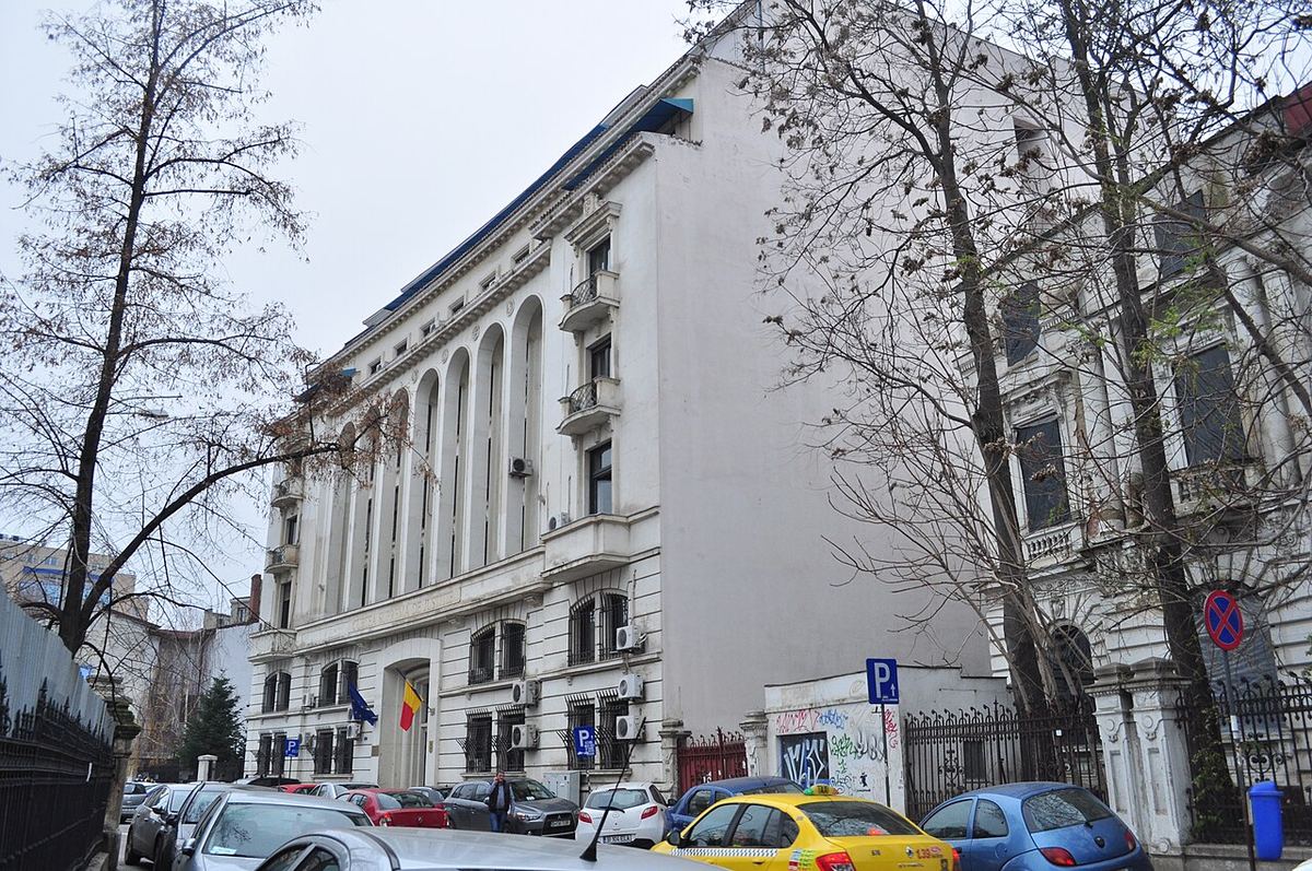 Fațada Înaltei Curți de Casație și Justiție din București, fotografiată ziua, cu steagul României la intrare.