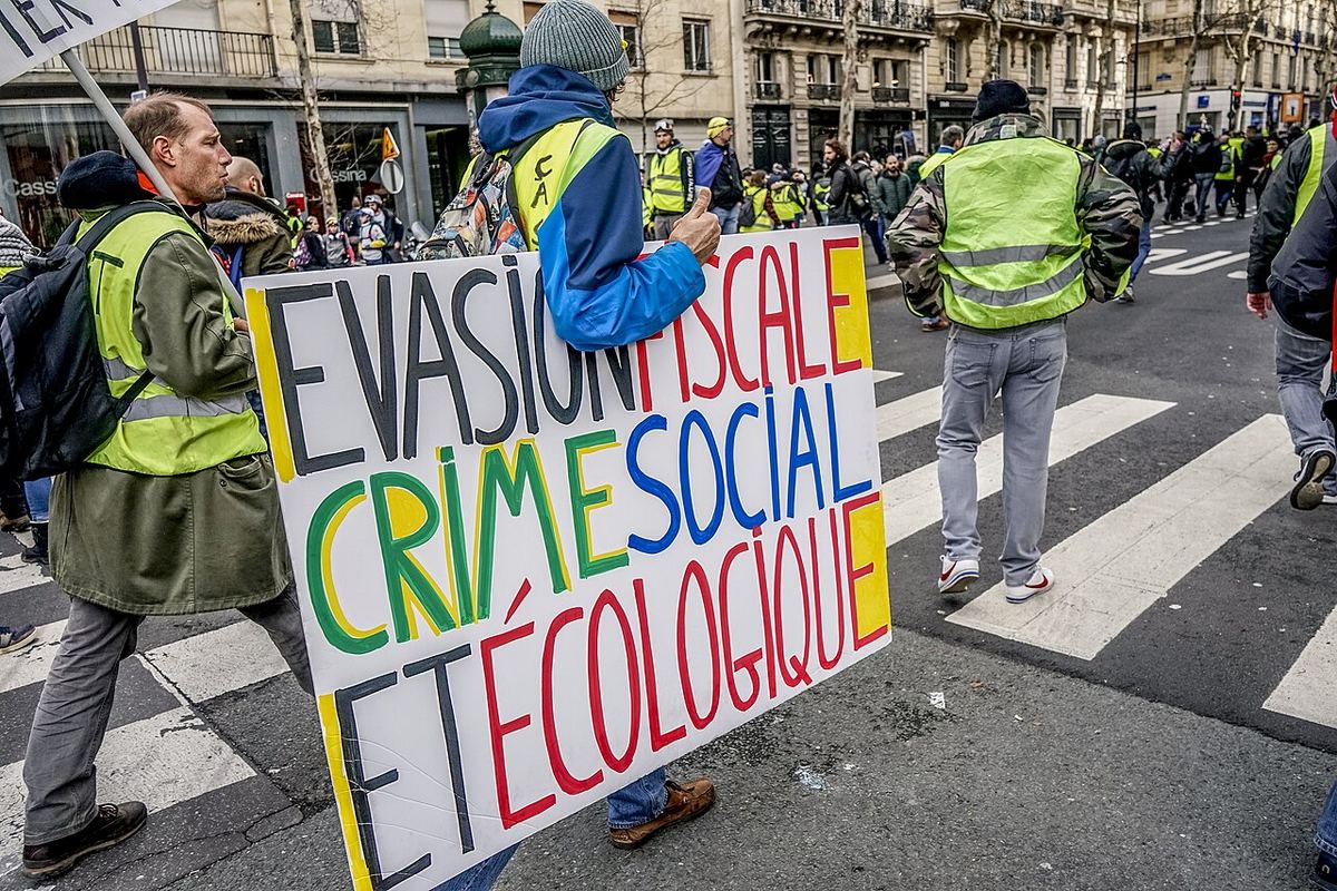 Manifestanți cu veste galbene protestând în Paris, cu cereri legate de taxele pe combustibil și de salarii.