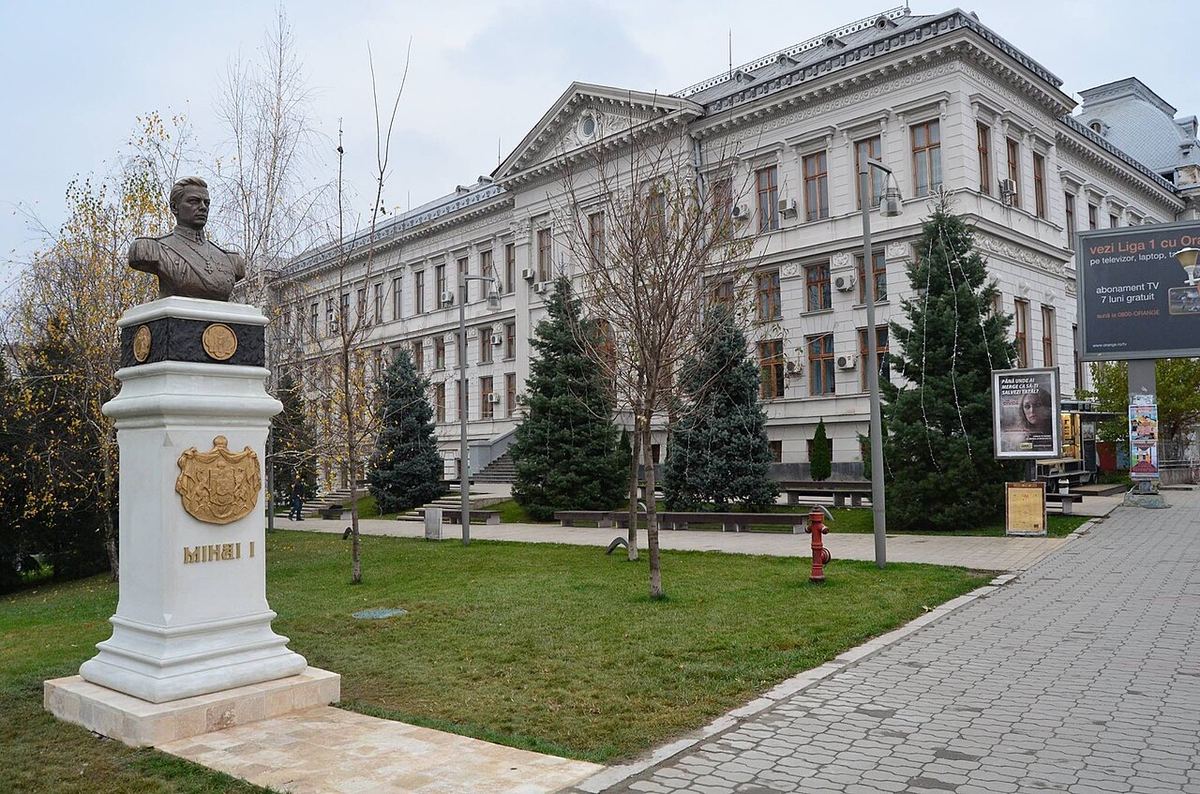 Monumentul regelui Mihai I din incinta Universității din Craiova, în fața unei clădiri universitare.