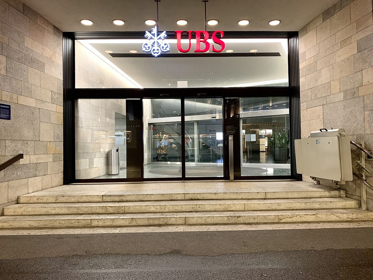 Intrarea clădirii UBS cu logoul și numele băncii vizibile, fotografiată seara, la Zürich (fotografie de arhivă).