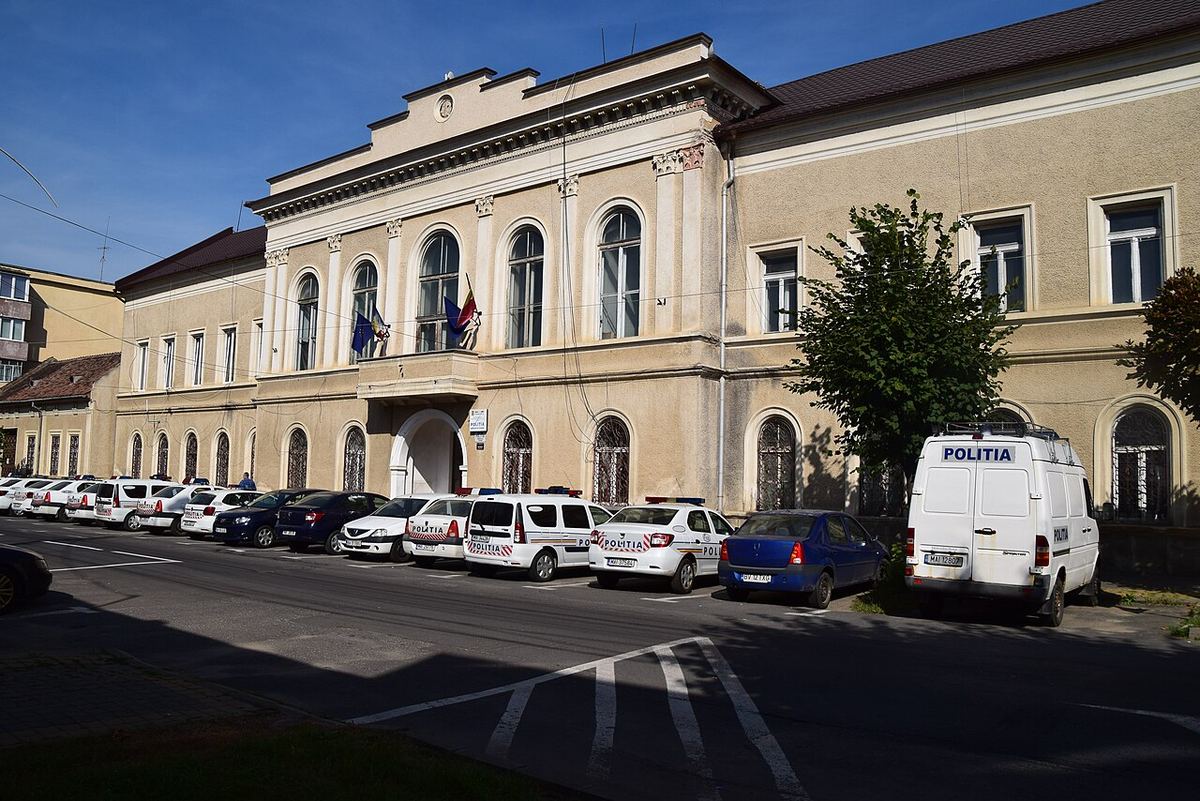 Clădirea fostei Prefecturi din Făgăraș, azi sediu al Poliției, cu autospeciale ale poliției parcate în față.