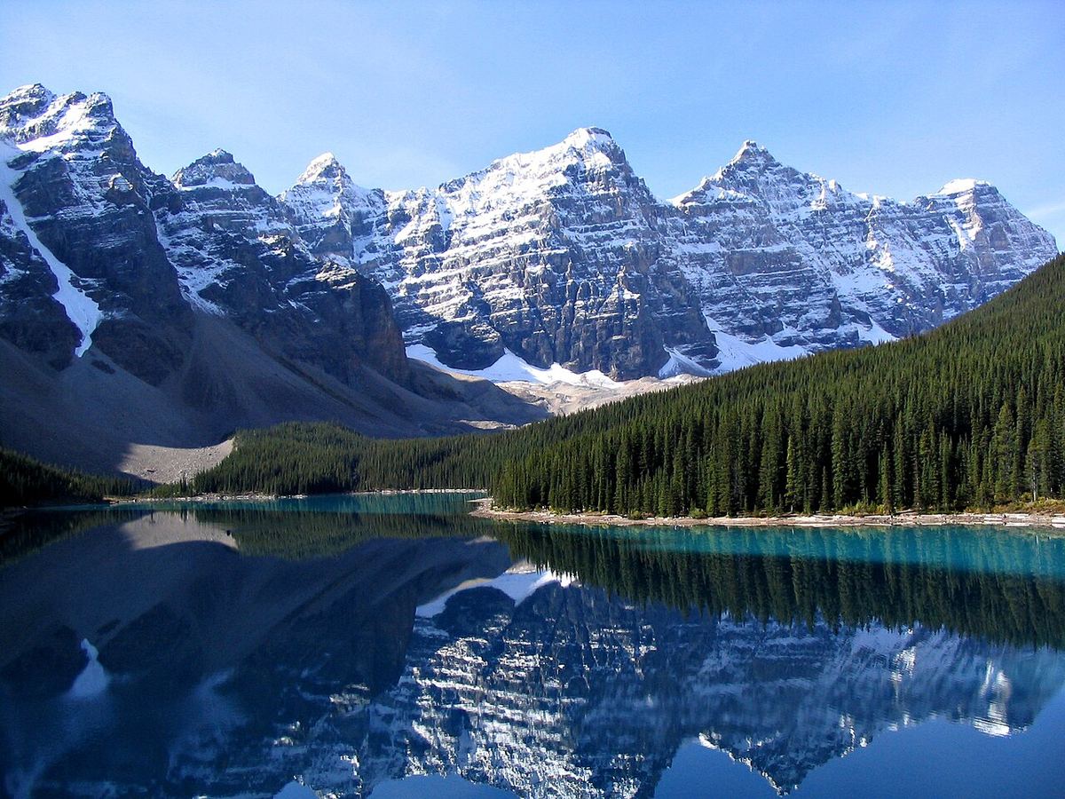 Lacul Moraine și munții Valea celor Zece Vârfuri, Parcul Național Banff, Alberta, reflectați în apă, cu pădure de conifere pe mal.