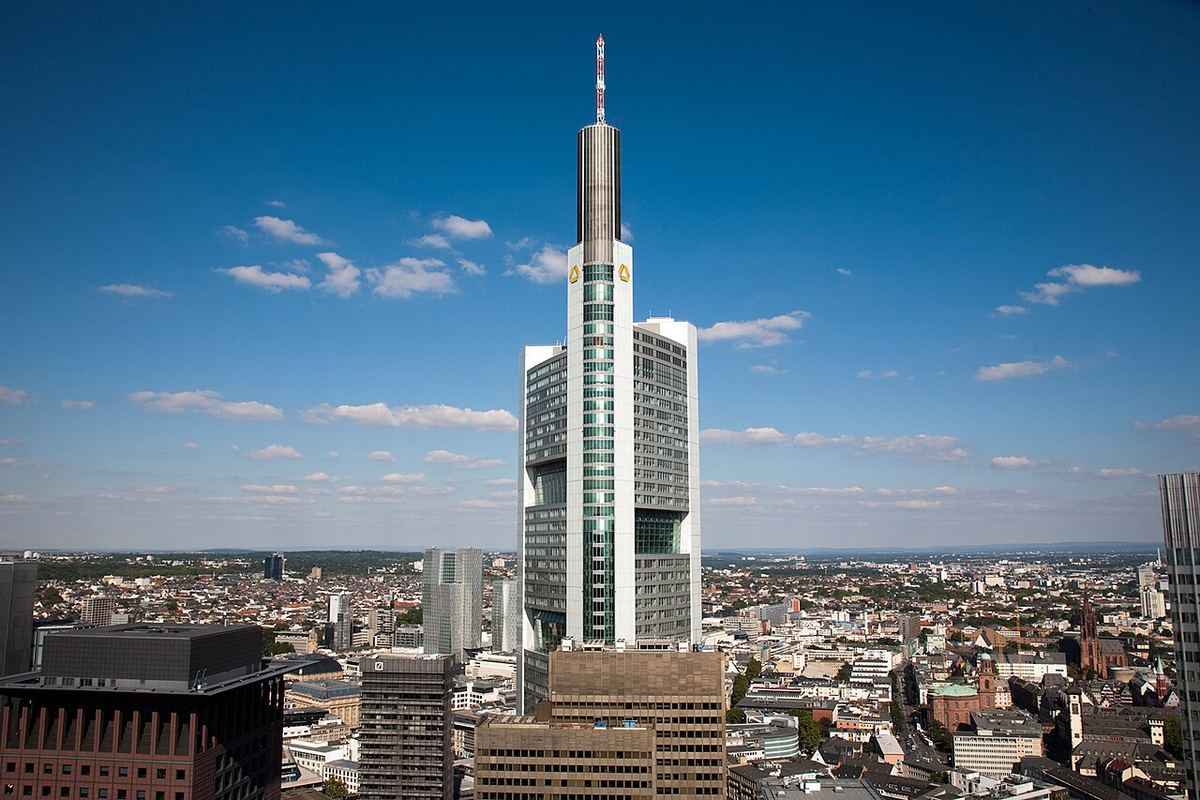 Turnul sediului Commerzbank din Frankfurt, cu orizontul orașului în fundal, fotografiat ziua (fotografie de arhivă).