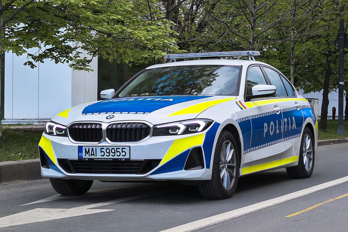Autoturism BMW Seria 3 al Poliției Române, în livrare albă și albastru-galben, parcat pe stradă, cu plăcuța MAI 59955.