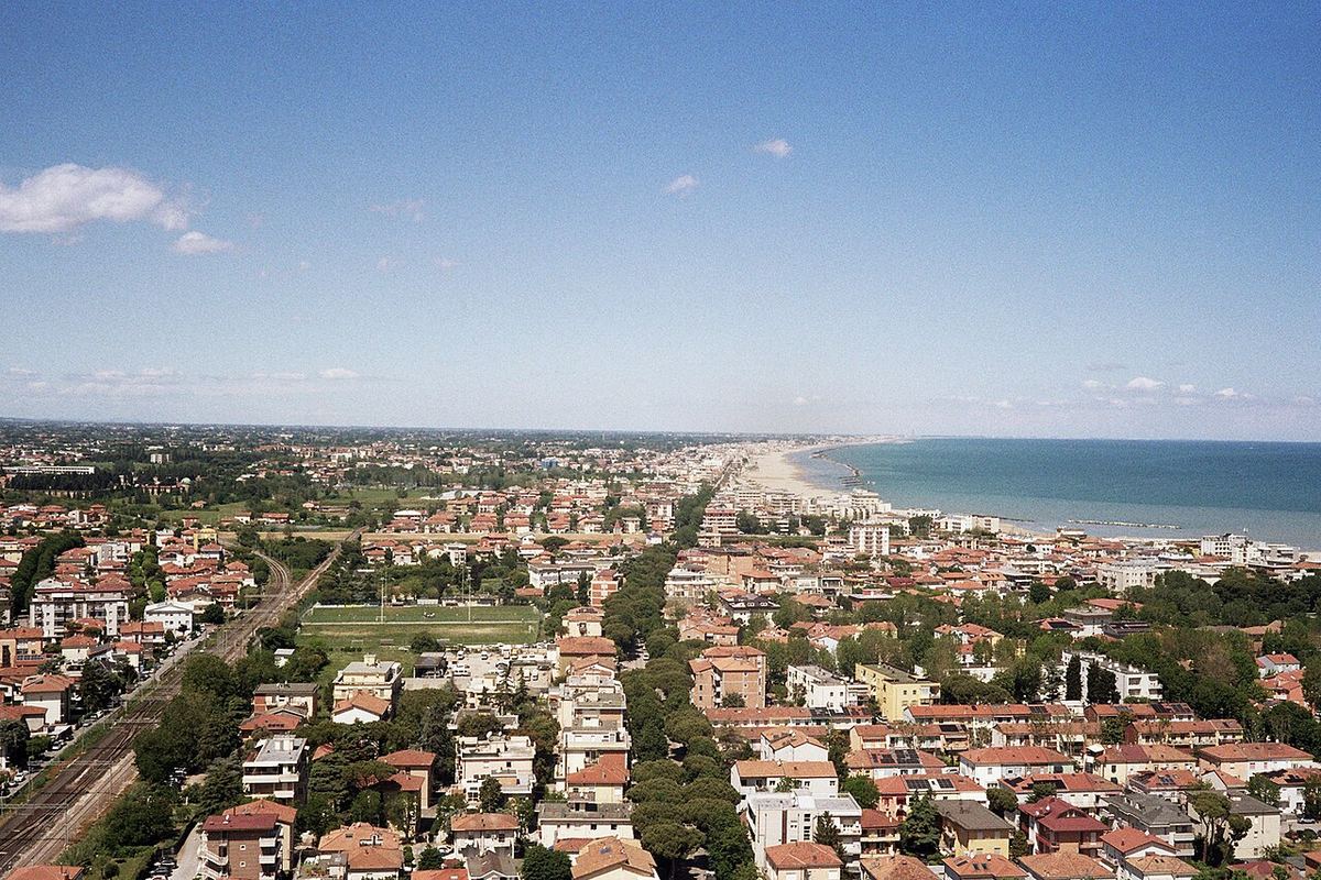 Vedere aeriană a litoralului din Rimini, de la etajul 26 al Grattacielo, cu linia ferată, zona verde și spațiul urban până la plajă.