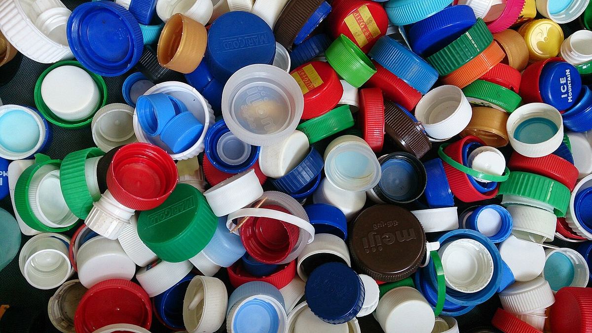 Capace de sticle din plastic, fotografiate de aproape, ilustrând ambalaje din plastic pentru reciclare.